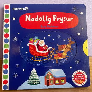 Cover of the book 'Nadolig Prysur' featuring illustrations of Santa Claus, a reindeer, and a Christmas tree with snow on the ground.