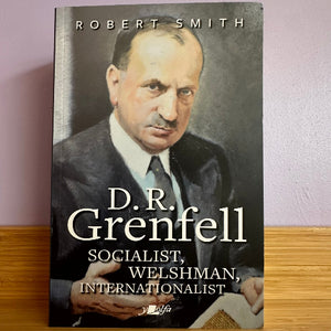 Book cover with a portrait of D.R. Grenfell and text about his life on a wooden surface.