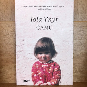 The image shows the cover of a book titled 'Camu - Iola Ynyr' featuring a photograph of a young girl wearing a pink sweater, seated against a textured background.