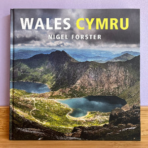 A book cover of 'Wales Cymru' by Nigel Forster featuring a photograph of a Welsh landscape with mountains and a lake.