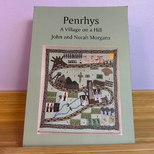 Cover of the book 'Penrhys - A Village on a Hill' showing a map design with various buildings and a title at the top.