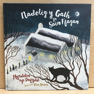 A book cover featuring a black and white illustration of a village with snow-covered roofs and a dark sky, with the title 'Nadolig y Gath yn Sain Ffagan - Myrddin ap Dafydd' and the author's name 'Elin Manon' at the bottom.