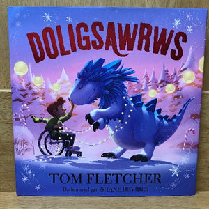 Book cover of 'Doligsawrws' featuring an illustration of a blue dinosaur with a human child and a wheelchair on the cover, set against a snowy backdrop with Christmas decorations.