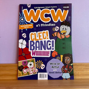 Magazine cover with colorful design and text on a wooden surface and purple wall background