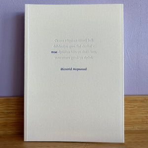White book with text on a purple wall and wooden surface