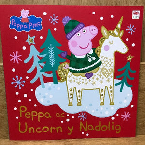 Cover of a children's book featuring cartoon characters Peppa Pig and a unicorn with Christmas-themed decorations such as trees and snowflakes.