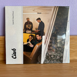 CD cover with a photo of people around a table on a wooden surface.