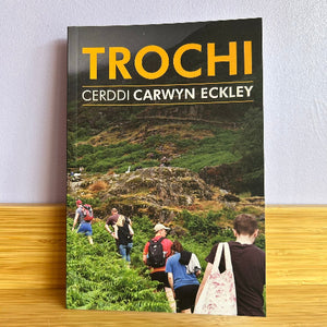 Book titled 'TROCHI' by Cerddi Carwyn Eckley on a wooden surface with a light gray background