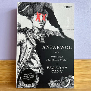 Book cover of 'Anfarwol' by Peredur Glyn with black and white illustration on a wooden surface and light purple background