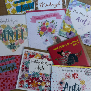 Collection of greeting cards with various designs and text on a wooden surface.