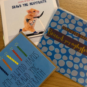 Two books with decorative covers and a small animal figure on a wooden surface.