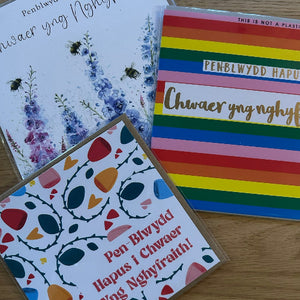 Three greeting cards with different designs on a wooden surface