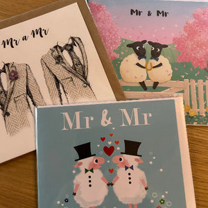 Three greeting cards featuring 'Mr & Mr' designs on a wooden surface.