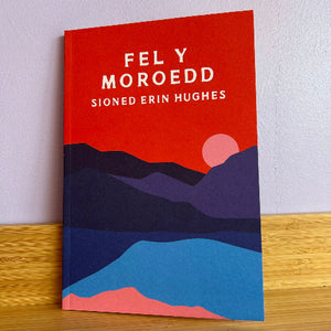 Book cover with mountain design and text on a wooden surface