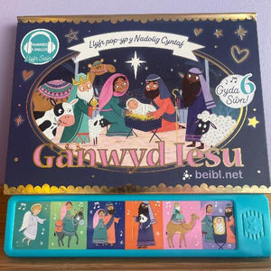 A booklet cover for 'Ganwyd Iesu: Llyfr pop-yp y Nadolig Cyntaf' featuring colorful illustrations of characters and a nativity scene, with a set of six interactive buttons displayed at the bottom.