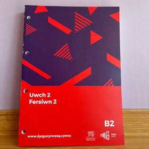 Coursebook with geometric pattern and text on a plain background