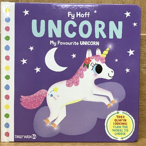 Children's book cover with a illustration of a white unicorn with stars and a rainbow pattern on its body, set against a purple background with stars and a crescent moon. The title 'Fy Hoff UNCORN' is displayed at the top.
