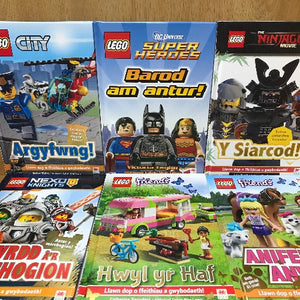 A set of six LEGO themed books in Welsh, with colorful covers featuring various LEGO characters and scenes.