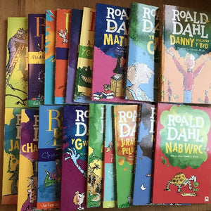 A collection of Roald Dahl books in Welsh, with colorful covers and titled 'Roald Dahl'.