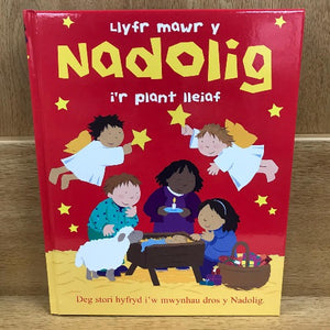 A book cover of 'Llyfr Mawr y Nadolig i'r Plant Lleiaf' featuring colorful illustrations of children and Christmas-themed elements like sheep, stars, and festive attire.