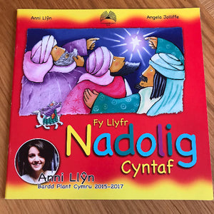 A book cover for 'Fy Llyfr Nadolig Cyntaf' featuring colorful illustrations depicting the Christmas story in Welsh, with the author Anni Llŷn and illustrator Angela Jolliffe pictured.