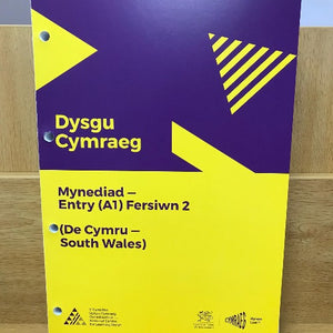A cover of the book 'Dysgu Cymraeg: Mynediad - Entry (A1) Fersiwn 2 (De Cymru - South Wales)' with yellow and purple design elements.