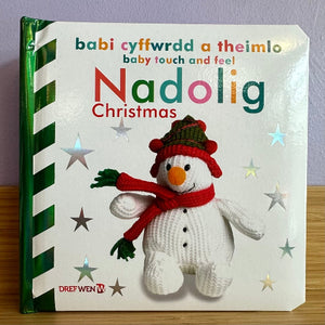 Children's book titled 'Nadolig Christmas' with a snowman illustration on a white background.