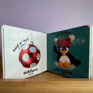 Open book with Christmas-themed pages featuring a red ornament and penguin.
