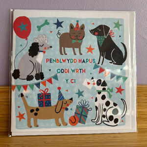 Greeting card with illustrations of dogs and celebratory elements on a blue background.