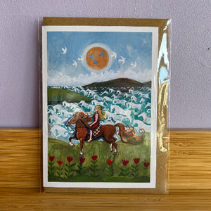 Greeting card with a horse and rider illustration on a wooden surface