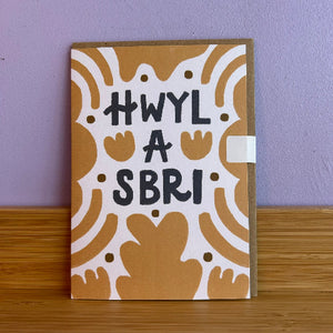 Card with decorative picture and text on a wooden surface and purple wall background