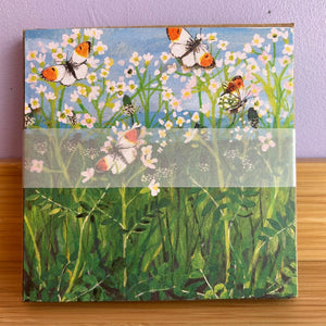 cards with a nature-themed design featuring butterflies and flowers on a wooden surface.