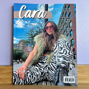 Magazine cover with a person wearing a zebra print outfit against a cityscape background