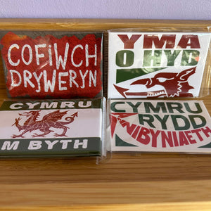 Collection of Welsh-themed magnets on a wooden surface