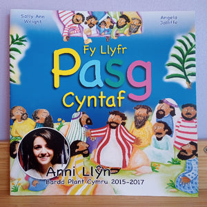 Children's book titled 'Fy Llyfr Pasg Cyntaf' with colorful illustrations and a photo of a woman on the cover.