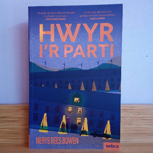 Book cover of 'HWYR I'R PARTI' with a blue background and illustration of houses and people.