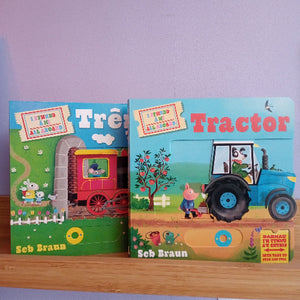 Two children's books titled 'Trên' and 'Tractor' by Seb Braun on a wooden shelf with a light purple wall background.