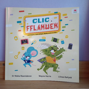 Children's book titled 'CLIC A FFLAMWEN' with colorful illustrations on a wooden surface.