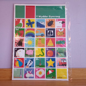 A Welsh alphabet poster for children, titled 'Y Wyddor Gymraeg'. The poster features a colorful grid of letters from A to Z, each paired with an illustrative picture.