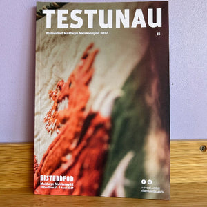 Programme cover titled 'TESTUNAU' with a blurred background