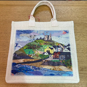 Tote bag with castle design on a wooden surface