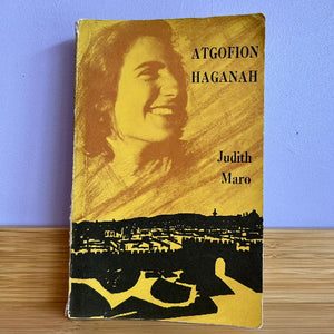 Book titled 'ATGOFION HAGANAH' by Judith Maro with a portrait on the cover against a blue wall.