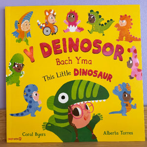 Children's book titled 'This Little Dinosaur' with colorful dinosaur illustrations on a yellow background.