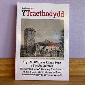 A printed book or magazine cover titled 'Y Traethodydd' with the text 'Gorffennai2026' at the top, photographed standing upright on a wooden surface against a light purple wall. The cover features a grayscale church building photograph and black and red text.