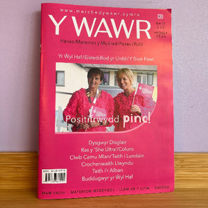 A pink Welsh magazine titled 'Y Wawr' (Hyd 2026, Rhif 233). The cover features a photo of two women in pink outfits holding a pink sign.