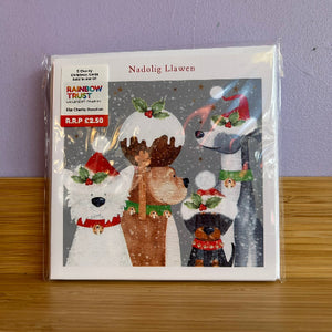 A packaged Christmas card set featuring illustrated dogs wearing Santa hats and holiday garlands on a snowy gray background. 