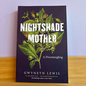 Book titled 'Nightshade Mother' by Gwyneth Lewis on a wooden surface with a light purple background