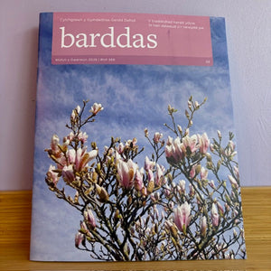 Book titled 'barddas' with a cover featuring blooming flowers against a blue sky.