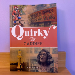 Book titled 'Quirky Cardiff' by Mark Rees on a wooden surface with a purple background
