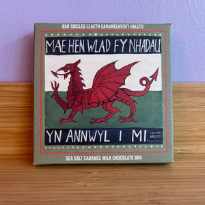 Chocolate bar packaging with a red dragon design on a wooden surface.